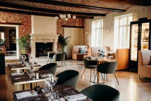 Aisonville-et-BernovilleにあるDOMAINE DES LUMIERESのテーブルと椅子、暖炉のあるレストラン