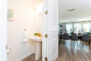 a bathroom with a sink and a mirror and a dining room at Cozy 3 Bd Close to Disney @ Enclaves at Festival 808 in Davenport