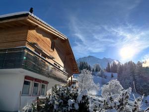 a snow covered house with a view of the mountains at Chalet Viola in Wengen