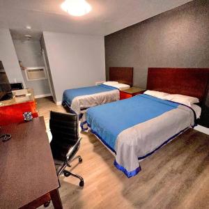 1 dormitorio con 2 camas, escritorio y silla en Reed Motel Nashville, en Nashville