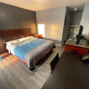 1 dormitorio con 1 cama y escritorio con TV en Reed Motel Nashville, en Nashville