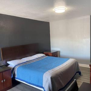 - une chambre avec un grand lit et une couverture bleue dans l'établissement Reed Motel Nashville, à Nashville