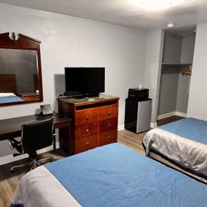 1 dormitorio con 2 camas y escritorio con ordenador en Reed Motel Nashville, en Nashville