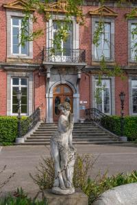 una estatua de un oso delante de un edificio en Aparthotel Domaine du Chateau de la Neuville en Tihange