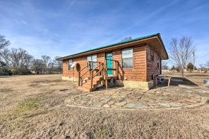 a small log cabin with a staircase in a field at Pet-Friendly Cabin Rental Retreat! 