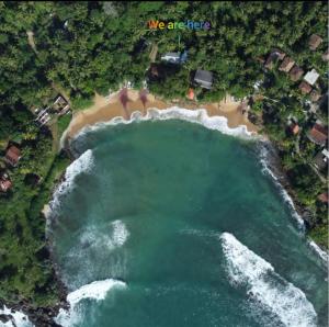 una vista aerea di una spiaggia e dell'oceano di Secret Swell a Tangalle