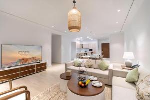 Mina Hotel and Residences By The Torch في الدوحة: غرفة معيشة مع أريكة وتلفزيون