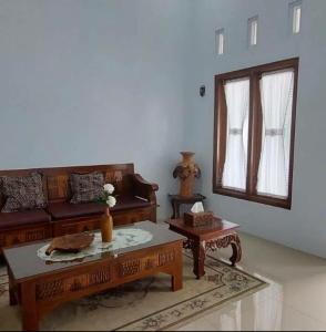 ein Wohnzimmer mit einem Sofa und einem Tisch in der Unterkunft Soraya Homestay in Tulungagung