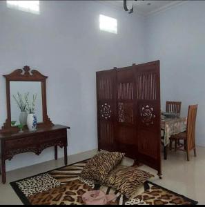 ein Wohnzimmer mit einem Tisch, einem Stuhl und einem Tisch mit einem Spiegel in der Unterkunft Soraya Homestay in Tulungagung