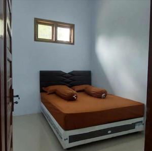 ein Bett mit zwei Kissen auf einem Zimmer in der Unterkunft Soraya Homestay in Tulungagung