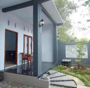 een veranda van een huis met een tafel en een stoel bij Soraya Homestay in Tulungagung