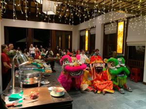 a group of people dressed in dragon costumes in a room at Nghê Prana Hotel & Spa Hoi An in Hoi An +85 photos
