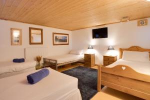 - une chambre avec 2 lits et une télévision murale dans l'établissement Chamonix Large Chalet, Sleeps 12, 200m2, 5 Bedroom, 4 Bathroom, Garden, Jacuzzi, Sauna, à Chamonix-Mont-Blanc