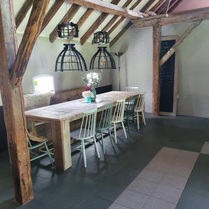 a dining room with a wooden table and chairs at Vakantiehuis Kleastermar met 12 slaapkamers in Oostermeer