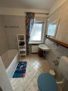 a bathroom with a tub and a sink and a toilet at Stilvolle Familienwohnung in Wörnsmühl in Fischbachau