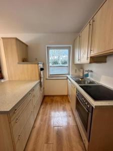 a kitchen with wooden cabinets and a sink and a window at Stilvolle Familienwohnung in Wörnsmühl in Fischbachau