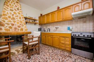 a kitchen with wooden cabinets and a stove top oven at Villa Kasta in Kavála