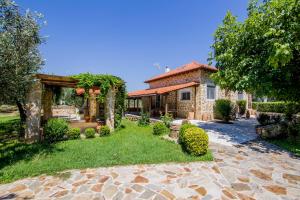 a stone house with a yard with a stone walkway at Villa Kasta in Kavála