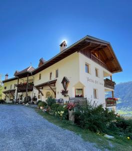 a large white building with a roof at Patztauhof in Sluderno