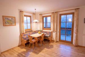 a dining room with a table and chairs and windows at Patztauhof in Sluderno