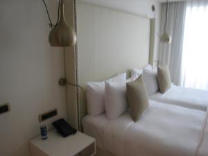 a hotel room with a white bed and a window at Apartamentas keliaujantiems pro Kauna toliau in Garliava