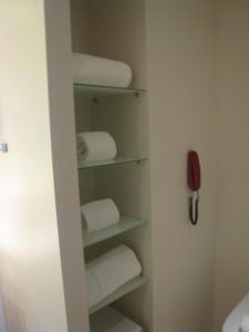 a bathroom with white towels and a phone on the wall at Apartamentas keliaujantiems pro Kauna toliau in Garliava