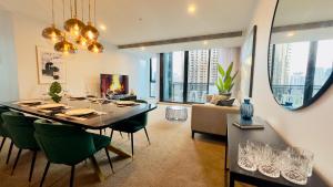 a dining room and living room with a table and chairs at Stylish Southbank apartment Plus Free Parking for 2 Cars in Melbourne