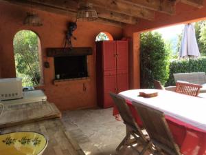 un patio con mesa, sillas y chimenea en Gite dans le maquis avec piscine privée, en Peri