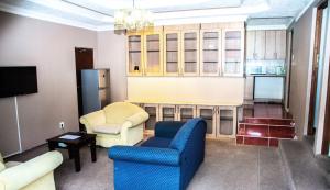 - un salon avec un canapé bleu et une chaise dans l'établissement @431 Rupert Street, à Pretoria