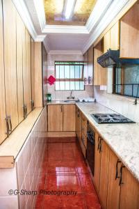 a kitchen with wooden cabinets and a red tile floor at @431 Rupert Street in Pretoria