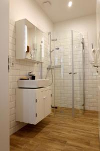 a white bathroom with a sink and a shower at Gut Boltenhof in Fürstenberg-Havel
