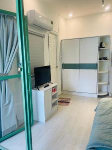 SNOW HOUSE HCR في مدينة هوشي منه: غرفة نوم مع تلفزيون وخزانة بيضاء