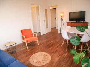 a living room with a couch and a table and a tv at Balcon du Champ de Mars - #Parking #Air Conditioner #Clim in Angoulême