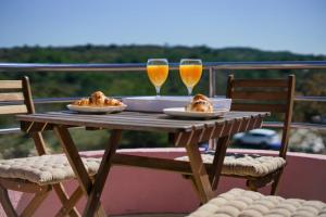 a wooden table with two glasses of orange juice and food at Apartment Nicol in Zadar