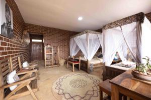 a room with two beds and a brick wall at Africa Safari Karatu in Karatu
