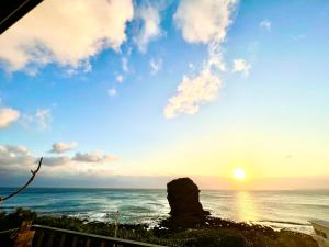 een uitzicht op de oceaan met zonsondergang bij Ming Jun Homestay in Eluan