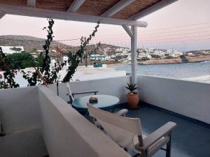 uma varanda com mesa e cadeiras e vista para o oceano em Astrofegia guest house em Donousa