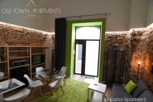 un soggiorno con porta verde e sedie bianche di Old Town Apartments Catania a Catania
