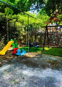 um parque infantil com escorrega e um baloiço em Villa Eirini with sea view em Dhriópi