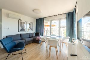 salon z kanapą, stołem i krzesłami w obiekcie Horyzont Apartamenty - Wyspa Solna w Kołobrzegu