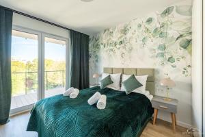 sypialnia z łóżkiem z ręcznikami w obiekcie Horyzont Apartamenty - Wyspa Solna w Kołobrzegu