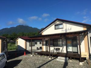 a white house with a porch and a patio at Cottage Kutsuroki in Yakushima