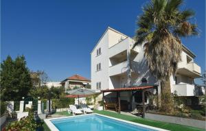 un hôtel avec une piscine en face d'un bâtiment dans l'établissement Pet Friendly Apartment In Split With Kitchen, à Split