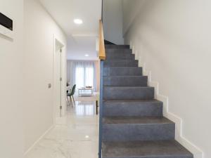 una escalera en una casa con paredes blancas y suelos de hormigón en Avatar Las Canteras, en Las Palmas de Gran Canaria