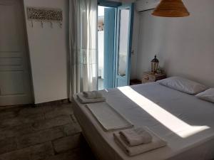 a bedroom with a large bed with towels on it at Astrofegia guest house in Donoussa