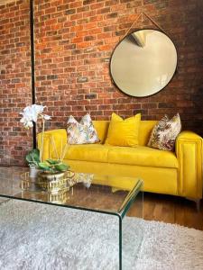 a yellow couch in a living room with a mirror at Joburg’s Cutest Condo. in Johannesburg