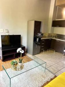 a living room with a glass table with flowers on it at Joburg’s Cutest Condo. in Johannesburg