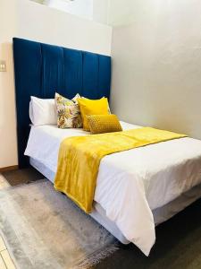 a bedroom with a large bed with a blue headboard at Joburg’s Cutest Condo. in Johannesburg