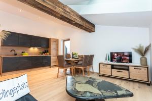 STOAMAT Appartements في لوفر: مطبخ وغرفة معيشة مع طاولة وتلفزيون