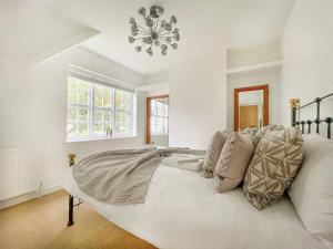 倫敦的住宿－Cheerful 3 bedroom luxury house，卧室配有一张带吊灯的大型白色床。